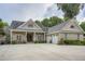 Beautiful brick home with an attached two-car garage, a charming front porch, and an elegant, arched double-door entrance at 4829 Moon Rd, Powder Springs, GA 30127