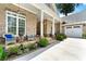 Inviting front porch with stone floor, white columns, and seating area, perfect for enjoying the outdoors at 4829 Moon Rd, Powder Springs, GA 30127