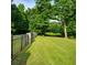 Spacious green yard bordered by a classic black fence and mature trees at 4829 Moon Rd, Powder Springs, GA 30127