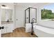 Modern bathroom features a soaking tub, sleek fixtures, a black-framed shower, and a window at 9744 Spyglass Dr, Villa Rica, GA 30180