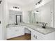 Bathroom with granite countertops and dual sinks illuminated by modern vanity lights at 9744 Spyglass Dr, Villa Rica, GA 30180
