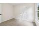 Bedroom featuring neutral carpet, a window, and a white door with black hardware at 9744 Spyglass Dr, Villa Rica, GA 30180