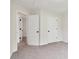 Bright bedroom featuring neutral carpet, a standard door, and a glimpse into an adjoining space at 9744 Spyglass Dr, Villa Rica, GA 30180