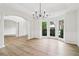 Bright dining room with large windows, light wood floors, chandelier, and wainscoting at 9744 Spyglass Dr, Villa Rica, GA 30180