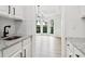 Bright dining room with view from kitchen, large windows, light wood floors, and chandelier at 9744 Spyglass Dr, Villa Rica, GA 30180