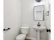 Modern powder room with pedestal sink, rectangular mirror, and sleek black fixtures at 9744 Spyglass Dr, Villa Rica, GA 30180