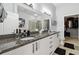 Bathroom featuring granite countertops with double sinks, modern vanity, and a view into the walk-in closet at 390 17Th Nw St # 6055, Atlanta, GA 30363