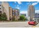 Building exterior view emphasizing architectural style, streetscape, and nearby high-rise buildings against a blue sky at 390 17Th Nw St # 6055, Atlanta, GA 30363