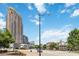 Street view of tall condo building and neighborhood with blue sky and scattered clouds at 390 17Th Nw St # 6055, Atlanta, GA 30363