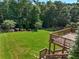 Expansive backyard with lush green lawn and mature trees viewed from wooden deck at 4050 Bonnett Creek Ln, Hoschton, GA 30548