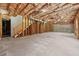 Unfinished basement with wooden frame walls, exposed ceiling insulation, and concrete floors offers customization at 4050 Bonnett Creek Ln, Hoschton, GA 30548