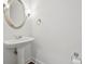 Bathroom featuring a white vanity sink and a round mirror at 4050 Bonnett Creek Ln, Hoschton, GA 30548