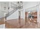 Spacious living area with hardwood floors, staircase, and adjacent kitchen, ideal for modern living at 4050 Bonnett Creek Ln, Hoschton, GA 30548