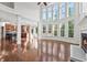 Bright living room with hardwood floors, fireplace, and large windows offering scenic views at 4050 Bonnett Creek Ln, Hoschton, GA 30548
