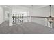 Spacious loft area with hardwood railing, stylish lighting, and ample natural light at 4050 Bonnett Creek Ln, Hoschton, GA 30548