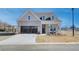 Charming brick home boasts a welcoming porch, tandem garage, and beautifully manicured front yard at 7310 Winderlea Ln, Cumming, GA 30040