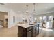 Bright, open kitchen with a large island and sink that opens to a dining area with lots of natural light at 7310 Winderlea Ln, Cumming, GA 30040