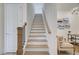 Bright staircase features wood railing and white risers, leading to the upper level at 7310 Winderlea Ln, Cumming, GA 30040