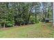 Scenic backyard with mature trees and a lush lawn at 112 Laguna Springs Dr, Woodstock, GA 30188