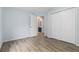 Spacious bedroom with wood-look floors, large closet, and open doorway to an attached bathroom at 112 Laguna Springs Dr, Woodstock, GA 30188