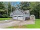 Rear of home showing spacious two car garage, extra storage shed, and well-manicured lawn at 112 Laguna Springs Dr, Woodstock, GA 30188
