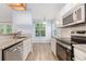 Modern kitchen featuring granite countertops, stainless steel appliances, and lots of natural light at 112 Laguna Springs Dr, Woodstock, GA 30188