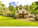 Scenic backyard view of a two-story home featuring a deck, covered patio, and lush greenery at 130 Brooklet Way, Brooks, GA 30205