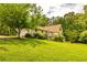 Landscaped backyard with a manicured lawn and mature trees surrounding the charming two-story home at 130 Brooklet Way, Brooks, GA 30205