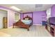 Spacious bedroom with laminate floors, a large bed, and a calming purple color scheme creating a relaxing atmosphere at 130 Brooklet Way, Brooks, GA 30205