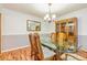 Elegant dining room with a glass table, wood chairs, and a wooden china cabinet at 130 Brooklet Way, Brooks, GA 30205