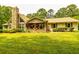 Charming ranch-style home with a stone chimney, inviting front porch, and lush green lawn at 130 Brooklet Way, Brooks, GA 30205
