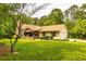 Inviting front exterior of a ranch-style home with well-kept lawn, stone chimney, and covered porch at 130 Brooklet Way, Brooks, GA 30205