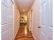 Hallway with warm wood floors leading to a comfortable bedroom, creating an inviting, cozy ambiance at 130 Brooklet Way, Brooks, GA 30205
