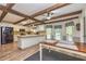 Bright kitchen and dining area with exposed wood beams, white cabinetry, and stainless appliances at 130 Brooklet Way, Brooks, GA 30205