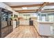 Spacious kitchen featuring white cabinets, stainless steel appliances, a large island, and rustic wood beam accents at 130 Brooklet Way, Brooks, GA 30205