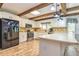Kitchen boasting white cabinets, stainless steel appliances, a center island, and exposed wood beams at 130 Brooklet Way, Brooks, GA 30205