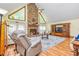 The living room is spacious with a stone fireplace, a ceiling fan, and hardwood floors at 130 Brooklet Way, Brooks, GA 30205