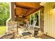 The covered front porch offers a stone floor and walls, rocking chairs and wood ceiling at 130 Brooklet Way, Brooks, GA 30205