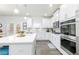 Bright kitchen featuring stainless steel appliances, white cabinets, and a spacious island ideal for cooking and entertaining at 895 Garnet Dr, Acworth, GA 30101
