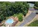 Aerial view of pool, tennis courts and parking with surrounding mature trees at 1120 Highland Bluff Se Dr, Atlanta, GA 30339
