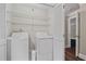 Laundry room with washer, dryer, shelves for storage, and a door to hallway at 1120 Highland Bluff Se Dr, Atlanta, GA 30339