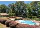 Community pool area surrounded by lush landscaping, featuring lounge chairs and umbrellas at 1120 Highland Bluff Se Dr, Atlanta, GA 30339