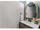 Stylish powder room featuring a vanity with a gold-framed mirror and textured wallpaper at 2169 Lanier Harbor Pt, Buford, GA 30518
