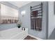 Bright bathroom featuring a soaking tub and stylish towel warmer at 2169 Lanier Harbor Pt, Buford, GA 30518