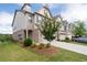 View of a townhome with a two-car garage, neat landscaping, and a manicured lawn at 2169 Lanier Harbor Pt, Buford, GA 30518