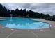 A community swimming pool with wading fountain and steps, surrounded by mature trees at 2189 Executive Dr, Duluth, GA 30096