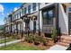 New townhomes with modern architecture, black wrought iron fences, and landscaped entryways at 628 Skytop Dr # 158, Cumming, GA 30040