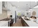 Open concept kitchen with stainless steel appliances, island seating, and seamless flow to the dining and living areas at 628 Skytop Dr # 158, Cumming, GA 30040