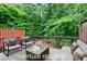Outdoor deck shows virtual staging with comfortable seating surrounded by a lush green view at 651 Coligny Ct, Atlanta, GA 30350