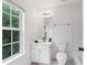 Bright bathroom with a large window, white cabinets, and a toilet at 651 Coligny Ct, Atlanta, GA 30350